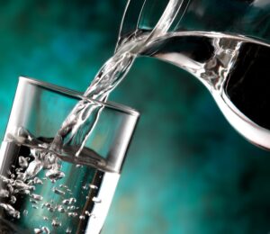 photo of water being poured into a glass from a jug