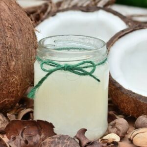 a jar of coconut kefir besides coconuts